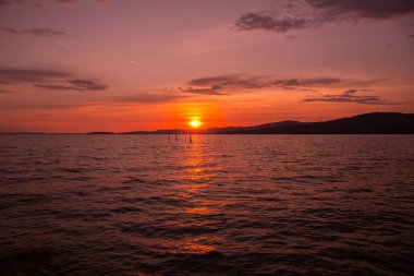 Mavi gökyüzü ve gün batımıyla manzaralı göl manzarası
