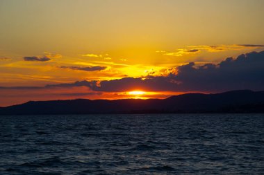 Mavi gökyüzü ve gün batımıyla manzaralı göl manzarası