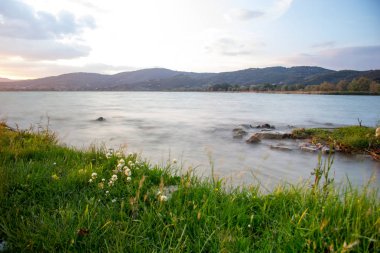 Mavi gökyüzü ve gün batımıyla manzaralı göl manzarası