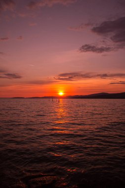 Mavi gökyüzü ve gün batımıyla manzaralı göl manzarası