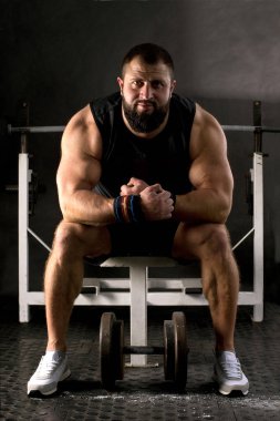 Güçlü kollu bir kaldırıcı ağırlık kaldırmaya hazırlanıyor. Spor salonunda kaslı adam eğitimi. Sağlıklı yaşam tarzı kavramı.