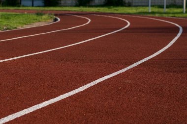 Stadyumda koşu pisti. Lastik kaplama. Temiz havada koşu bandı. Sağlıklı yaşam tarzı kavramı. Sporcuların kardiyo çalışmaları