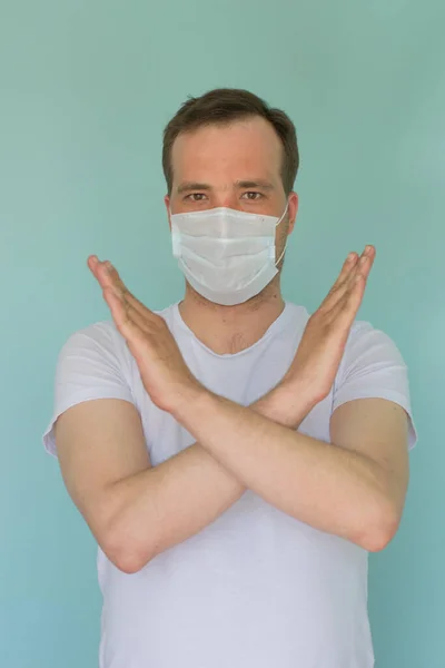 Retrato de un hombre atractivo con una máscara médica y un guante sobre fondo azul. Concepto de Protección Pandémica. Detén el coronovirus. Covid-19 — Foto de Stock