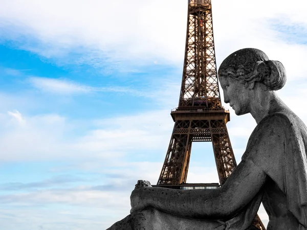 A Torre Eiffel em Paris nos braços de uma estátua de uma mulher sentada — Fotografia de Stock