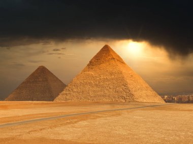 Giza, Mısır - 29 Ocak 2020 - Deve ve insanlarla dolu bir piramidin önünde dramatik gün batımına kadar turizm koşuşturması