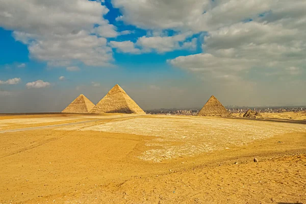 Giza, Mısır 'daki ünlü piramitler mavi bulutlu gökyüzüyle