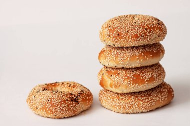 Beyaz arka planda susamlı taze ev yapımı simit.