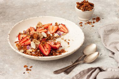 Yoğurtlu lezzetli kahvaltı, böğürtlen ve granola gri masada.