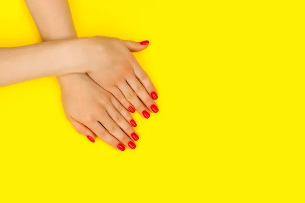 Beautiful woman manicure on trendy yellow background.