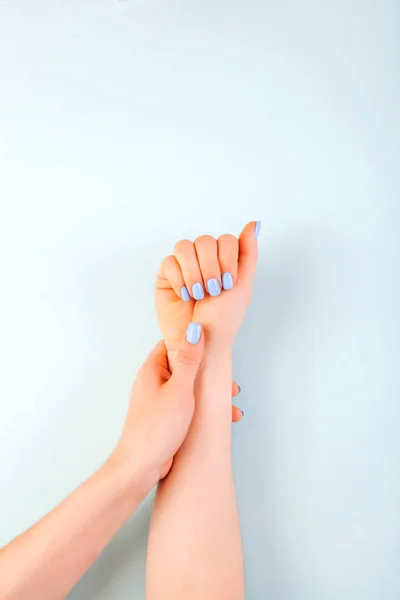 Beautiful woman manicure on creative trendy blue background. Copy space for text.