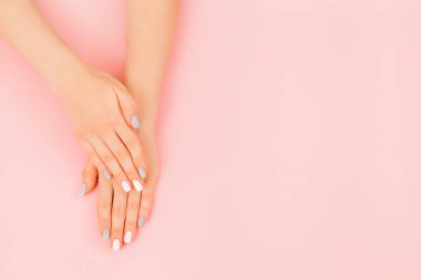 Pembe arka planda mükemmel gri manikürlü güzel bir kadın eli..