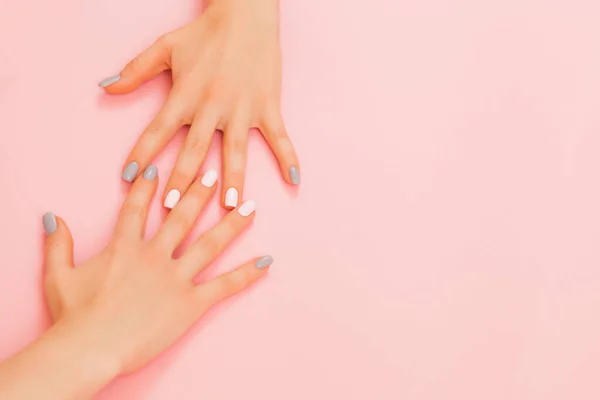 Manos de una hermosa mujer sobre un fondo rosa. Manos delicadas con manicura natural . — Foto de Stock