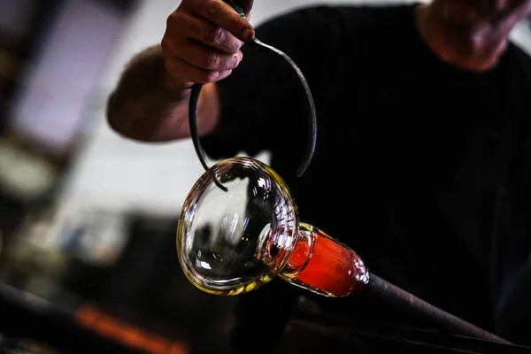 Cam üfleyici güzel bir cam parçası oluşturuyor. Bir cam ustası bir sanat eserini yakıyor ve üflüyor. Cam üfleyici ürününü dikkatlice üretiyor. Cam üfleme işlemi