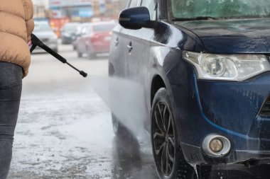 Kirli araba kışın soğuk havada elle yıkanır. ıslak işler.
