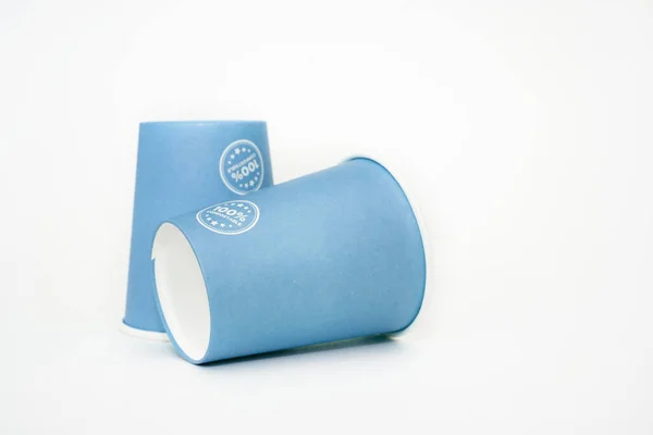 Two paper cups recyclable in blue on a white background. ecological concept Royaltyfria Stockbilder