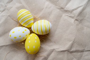 Paskalya sarısı süslemeli yumurtalar ve buruşuk el işi kağıt kaplama arka plan. Asgari paskalya konsepti. Mesaj için fotokopi alanı olan mutlu Paskalyalar. Üst görünüm, düz görünüm.