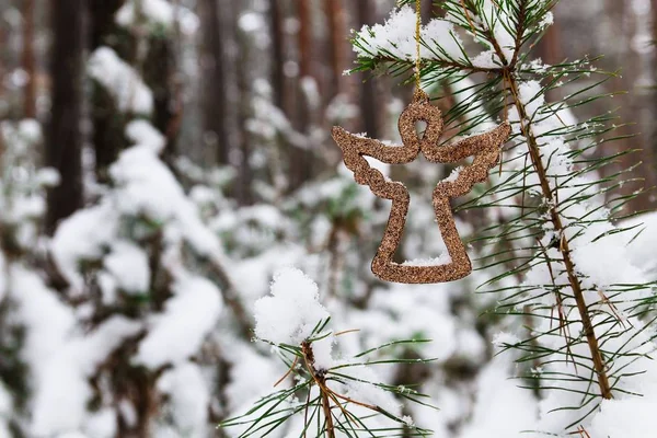 Ángel de Navidad en una rama de pino en un bosque nevado — Foto de Stock