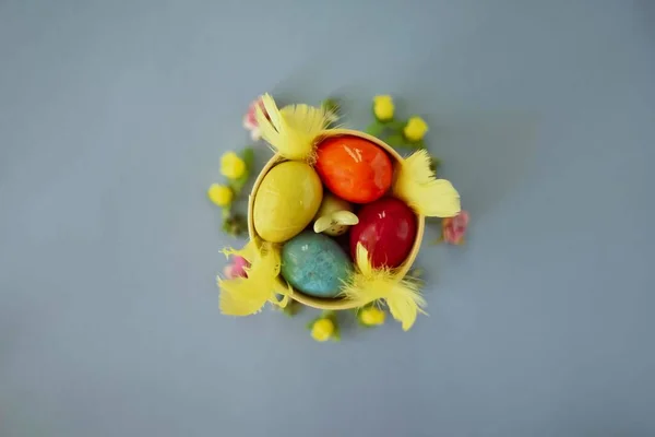 Colored easter eggs in a yellow bucket on a blue background — Stock Photo, Image