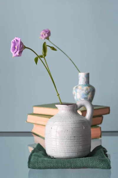 Retro home decor: a stack of books, flower in a vase — Zdjęcie stockowe