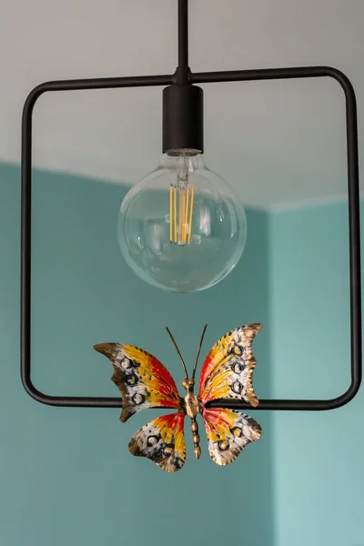 Light bulb with a metal butterfly. Loft style — Stock Photo, Image