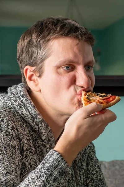 Pizza yiyen adam evde yemek yiyor, dinleniyor. — Stok fotoğraf