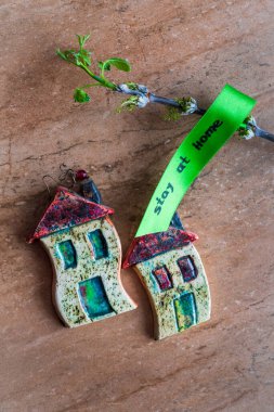 Yazıt evde kalıyor, seramik evler ve yapraklı bir dal.