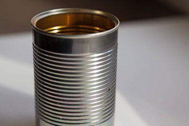 Boş bir teneke kutu ve mutfak masasının üzerinde duruyor.