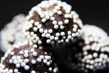 Yuvarlak beyaz şeker tanecikli pralinaları yakın plan yumrukla