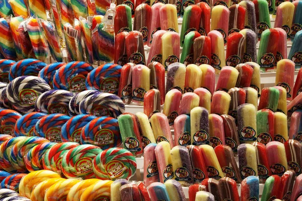 Diferentes piruletas montadas en una pared en una tienda de dulces — Foto de Stock