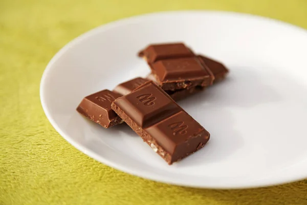 Chocolate bar and pieces on a white plate — Stock Photo, Image
