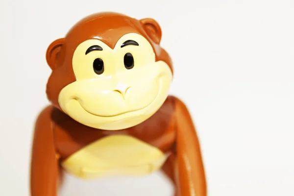 happy toy monkey in plastic on white background