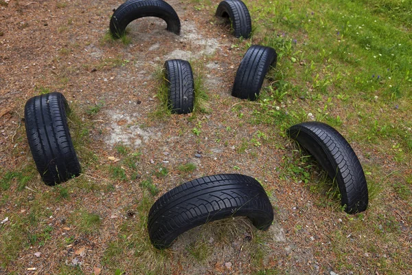 Neumáticos enterrados en el suelo a la carrera de obstáculos — Foto de Stock