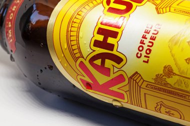 Beyaz arka planda kahve likörü olan bir şişe.