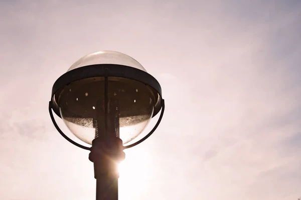 Parte superior de uma lâmpada de rua em pôr-do-sol com luz traseira — Fotografia de Stock