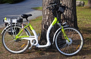 Umedalen 'de bir ağacın yanına park edilmiş yeni bir elektrikli bisiklet.