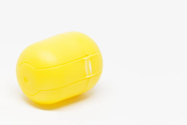 Un huevo de juguete amarillo cerrado sobre fondo blanco — Foto de Stock