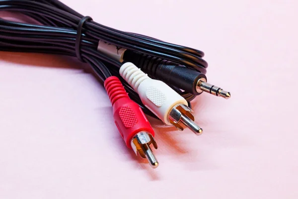 red and white RCA and 3.5 mm audio cable on pink background