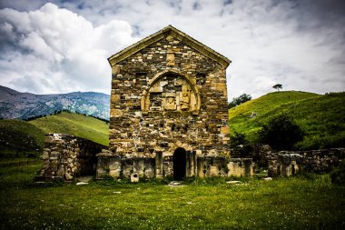 Tkhana Erdy (or Thaba Erdy) medieval christian temple (VIII century) and moutains of the Northern Caucasus on the background. One of the oldest temples in Russia. Ingushetia, Russia
