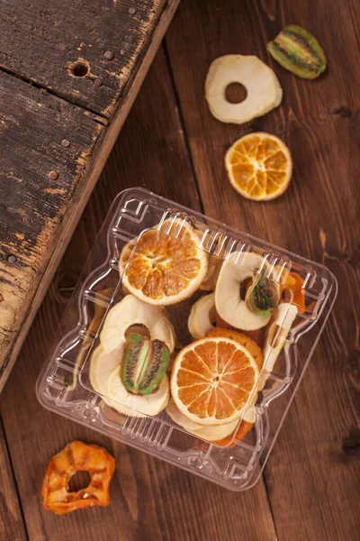 Plastik bir kabın içinde kurumuş meyve.