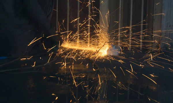close up of sparks made by angle grinder in a workshop with black background.golden sparks of grinder.