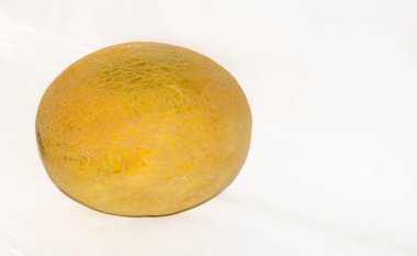 Beyaz arka planda izole edilmiş olgun taze kavun meyvesinin kapağı. Sarı kavun seçici odak noktası..