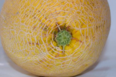 Beyaz arka planda izole edilmiş olgun taze kavun meyvesinin kapağı. Sarı kavun seçici odak noktası..