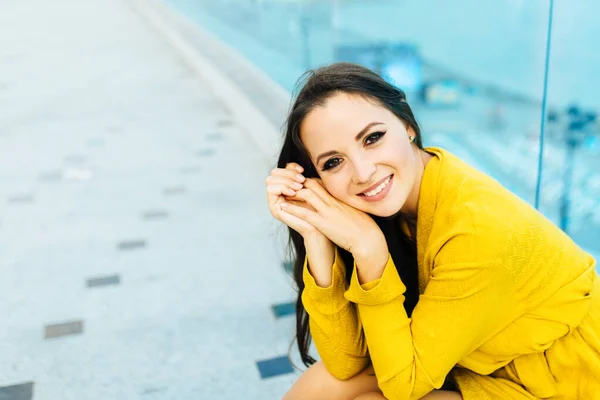 Mujer atractiva joven cerca del mar en el día de verano u otoño. sentado en el paseo con un vestido amarillo. aspecto elegante — Foto de Stock