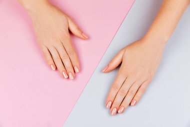 Güzel Kadın Eller pembe gri arka planda. Spa ve Manikür konsepti. Pembe manikürlü kadın elleri. Yumuşak cilt konsepti. Güzellik tırnakları