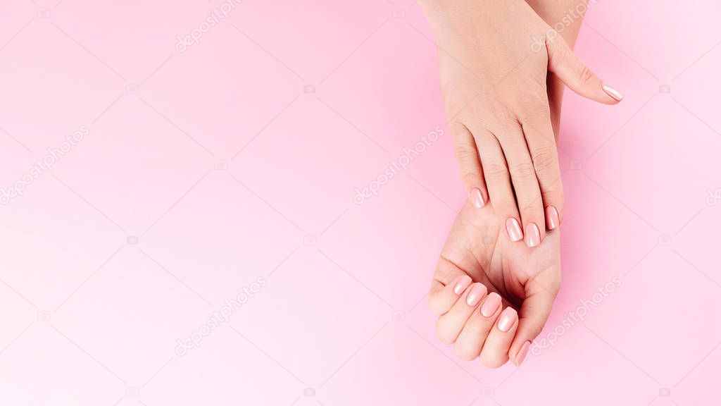 Beautiful Woman Hands on pink backgrounda. Spa and Manicure concept. Female hands with pink manicure. Soft skin skincare concept. Beauty nails