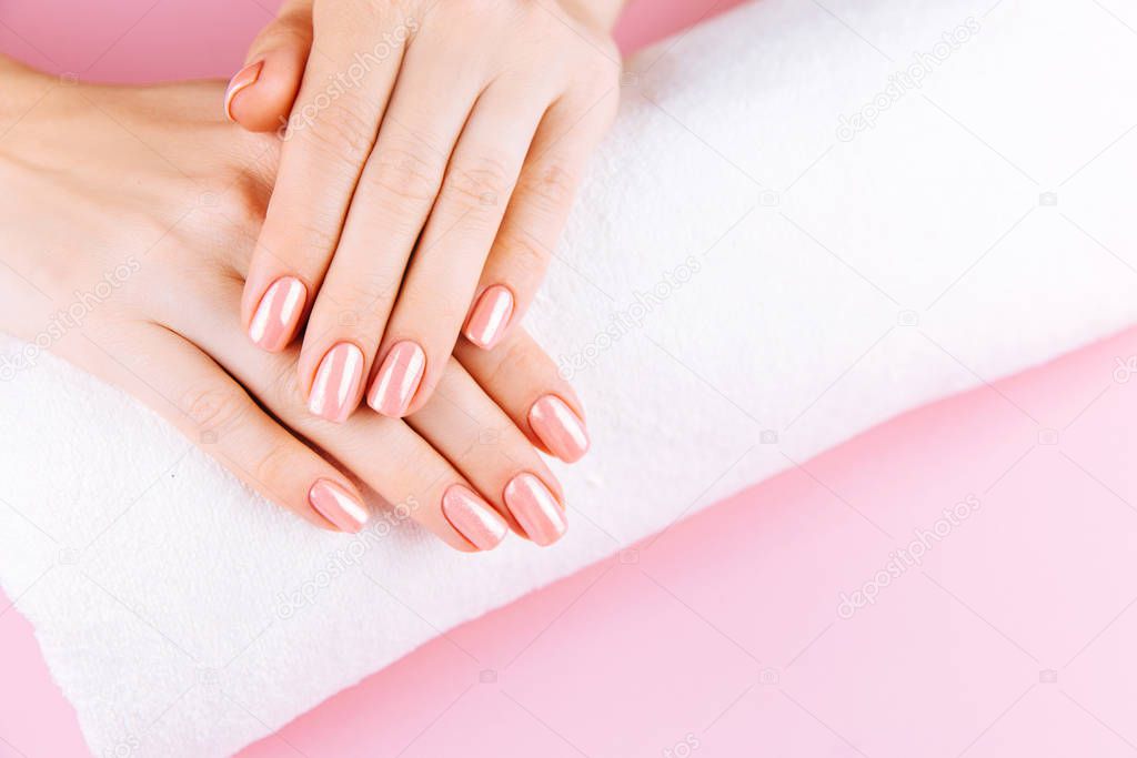 Beautiful Woman Hands . Spa and Manicure concept. Female hands with pink manicure. Soft skin skincare concept. Beauty nails. Over beige background.