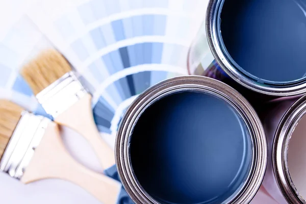 Pinceles colocados en la parte superior de la lata llenos de pintura azul. Clásico color azul del año 2020 . —  Fotos de Stock