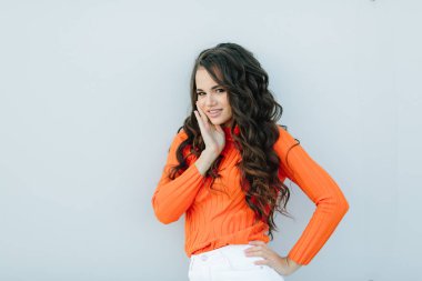 Genç ve parlak bir geçmişi var. Neşeli ve büyüleyici bir gülümsemeyle kameraya bakıyorum. Sonbahar kıyafetleriyle sokakta poz veren harika bir genç kadın, kot pantolon, ışıltı stili, yeniyetme moda kıyafeti, ruh hali, model.