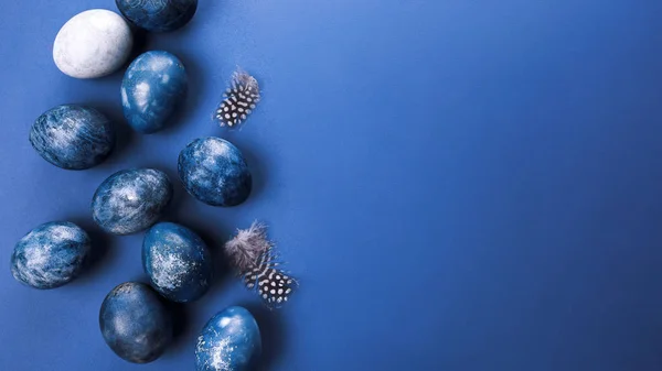 Hermosos huevos de Pascua azul ombre grupo con huevos de codorniz y plumas sobre un fondo azul. Concepto de Pascua. Huevos fronterizos. Copiar espacio para texto — Foto de Stock