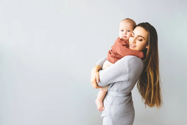 Una madre felice che regge la sua bambina. Giovane bella madre tiene il suo bambino e coccole, concetto di maternità . — Foto Stock